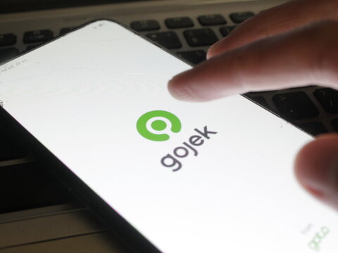 Klaten, Central Java - Indonesia - May 20 2024: A person opens the Gojek application to access various services such as transportation, food delivery, logistics, payment, and daily needs.