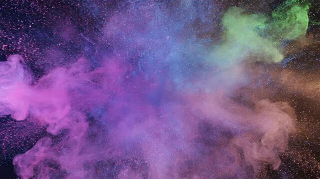 Fluid particles create liquid shapes and glowing colors in dark space with multicolor lights