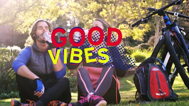 Cycling duo pausing after ride, hydrating with bottles while GOOD VIBES overlay animating over them