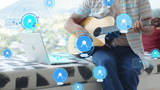 Man using laptop, fretting and strumming guitar on window seat for music, blue UI icons overlaying