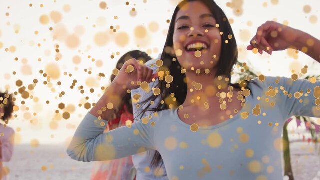 Forward camera urging focus to dancing woman at beach for promo, gold bokeh drifting over faces