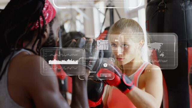 Coach holding mitts cueing trainee punching in boxing gym, spawning AR graphs tracking performance