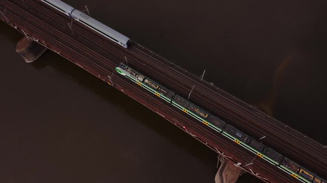Aerial Regional Green Train Linking Suburbs Across Bridge Warszawa In Evening Light, Steady Passenger Service, Modern Carriages, Suburban Commute And Transit Network Perspective.