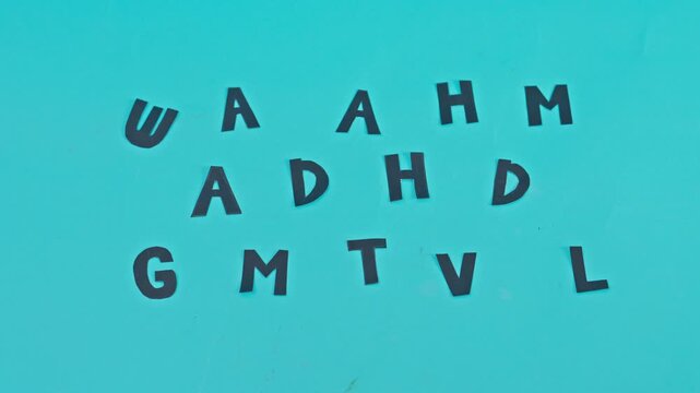 Stop-motion animation of black letters change word ADHD appears on blue background