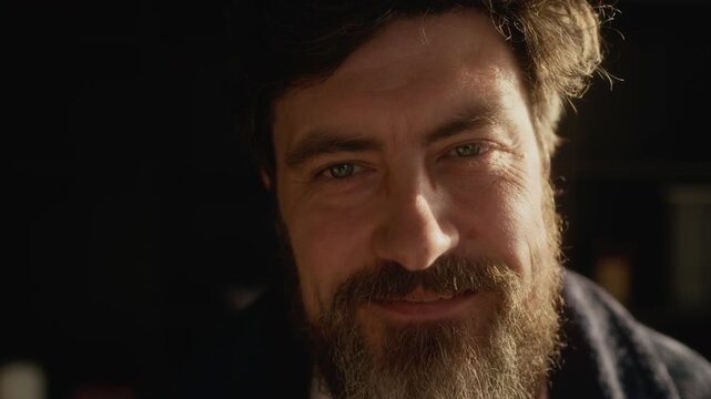 Close up portrait of bearded Caucasian writer holding novel typescript and pencil looking at camera