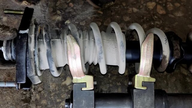 Impact wrench loosening a bolt on a compressed car spring