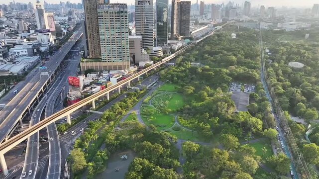 BTS skytrain rail line running above roads between buildings and city blocks. Elevated track connects urban areas with transportation system.