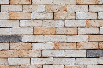 Fototapeta premium Modern pastel colored brick wall texture with beige and orange tones