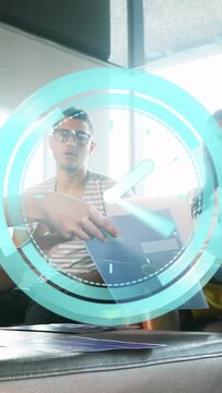 Vertical video: Hand placing blue folder while team reviewing papers in office, AR clock rotating