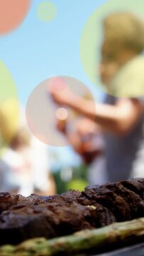 Vertical video: Food host grilling meat and veg for meal, guests reaching, circular overlays moving