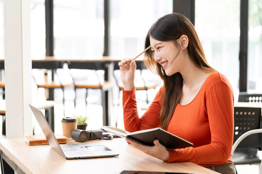 Happy Asian Woman Getting Creative Inspiration While Working in Cafe