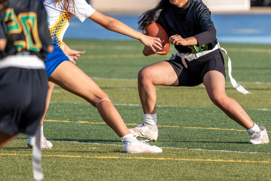 Flag football athlete running the ball attempts to evade tackle