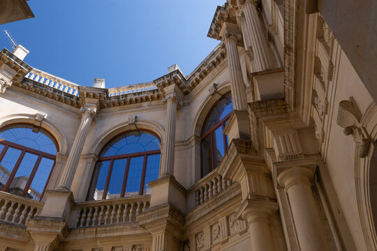 &Aacute;ngulo contrapicado de la Logia veneciana en Creta. Detalle arquitect&oacute;nico de columnas, balaustradas y ventanas bajo el intenso cielo azul mediterr&aacute;neo.