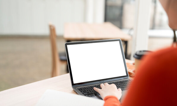 Woman working on laptop with blank white screen mockup