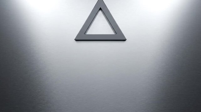 A simple, dark gray triangle shape is centered on a brushed metal background with a soft, diffused light shining from above