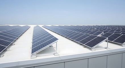 Fototapeta premium Extensive solar panel installation on a large industrial rooftop under a clear blue sky.