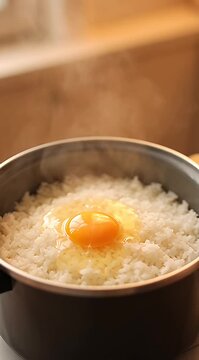 Steaming hot pot of rice with egg on top in kitchen