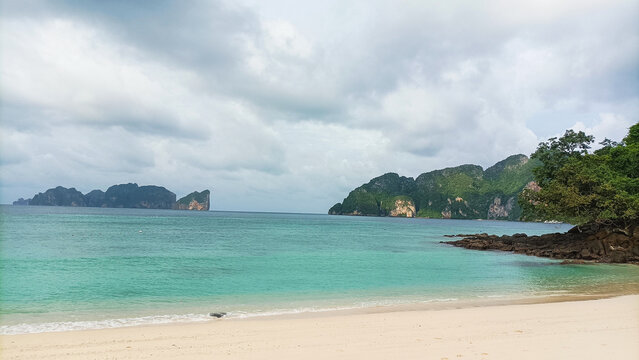 Phi Phi Island on August 15, 2025: Tropical beach shoreline with turquoise ocean and rocky cliffs