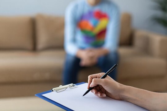 Mental health therapy session psychologist taking notes during counseling for depression anxiety trauma or lgbtq issues. High quality photo