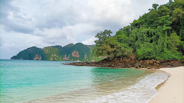 Phi Phi Island on August 15, 2025: Tropical beach shoreline with turquoise ocean and lush hills