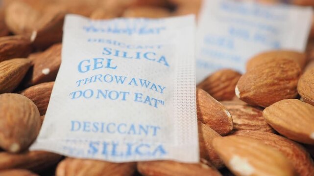 Silica gel packets sit among almonds to keep them fresh and dry