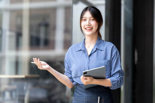 Successful Asian businesswoman with digital tablet and coffee