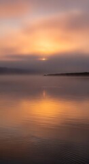 Fototapeta premium Stunning golden sunrise reflecting over a calm tranquil lake at dawn.