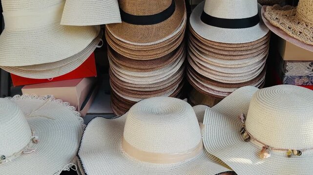 Assortment of elegant straw sun hats for women displayed at a tropical street market. Concept of summer fashion, beach accessories, and holiday shopping during a vacation in Phuket, Thailand.
