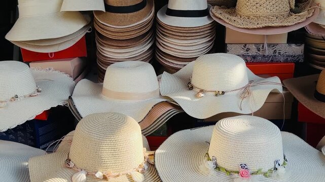 Assortment of elegant straw sun hats for women displayed at a tropical street market. Concept of summer fashion, beach accessories, and holiday shopping during a vacation in Phuket, Thailand.