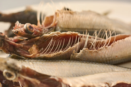 dried salted small fish with rib bones and silver scales, side view with soft focus, asian culinary ingredient concept