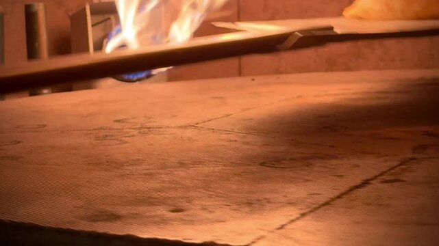 Fresh Pita Bread Inflating in Stone Oven, Industrial Rotating Oven with Burning Flame