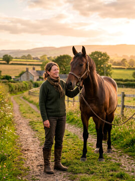 Mulher rural ao lado de cavalo em paisagem de campo ao entardecer