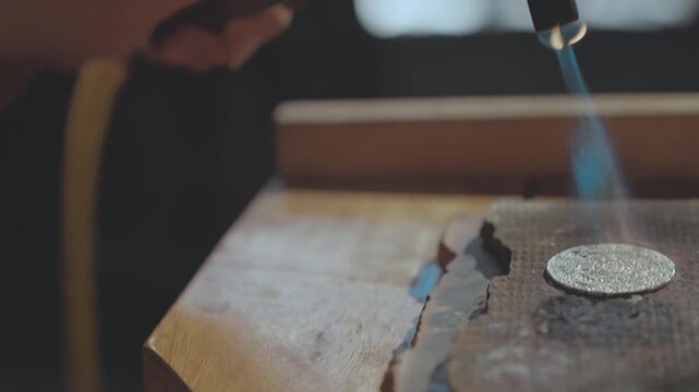 Close-up of Silver Artisan Lighting a Blowtorch with a Lighter in Workshop
