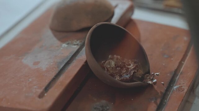 Silversmith Heating Silver Scraps on Clay Pot with Intense Fire Flame in Jewelry Workshop