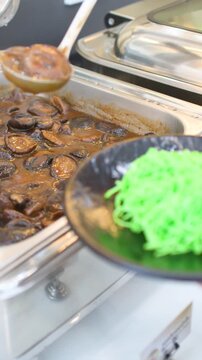 Server Scooping Shiitake Mushroom Stew at a Bangkok Buffet