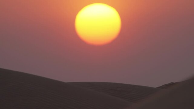 Timelapse Large Telephoto Sun Setting Below Sand Dunes, Cinematic Desert Sunset in Rub' al Khali Empty Quarter Oman