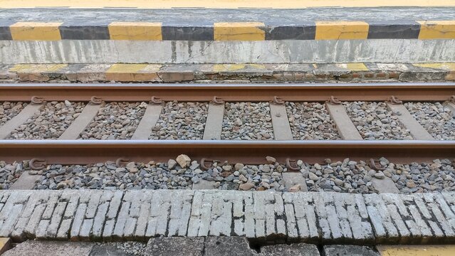 Industrial railway tracks with gravel ballast and sturdy sleepers, forming a crucial transportation link for trains and cargo movement across the landscape