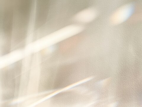 Abstract prismatic light flow and rainbow refraction on neutral textured wall for luxury wellness branding