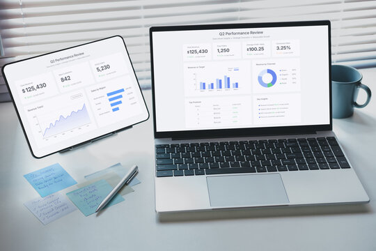 Remote work presentation scene with business performance dashboard displayed on laptop and tablet, showing analytics charts, KPI metrics, and data insights for strategic decision making in workspace