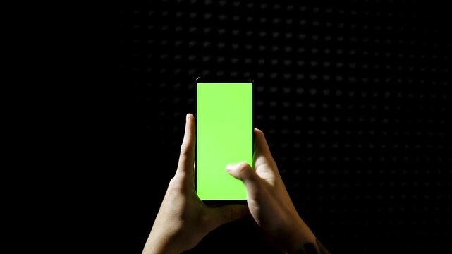 using Smartphone with Green Mock-up Screen green chroma key screen, hand gesture scrolling on device, empty space template dark background