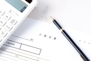 請求書 - 取引先へ宛てて請求書を準備する、ビジネスシーンのイメージ  © PJM