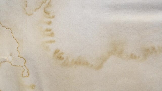 Old vintage paper texture background with aged stains and antique yellowed parchment effect