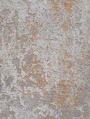 Fototapeta premium Old concrete wall, damaged, uneven structure, with remnants of yellow paint, vintage background for design