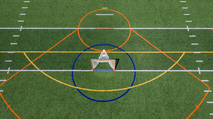 Aerial view of a multi-purpose athletic turf field featuring a lacrosse goal within a blue circular crease and overlapping colored lines for different sports.  Lacrosse, Soccer, Field Hockey, Football © Thomas