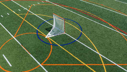 Aerial view of a multi-purpose athletic turf field featuring a lacrosse goal within a blue circular crease and overlapping colored lines for different sports.  Lacrosse, Soccer, Field Hockey, Football © Thomas