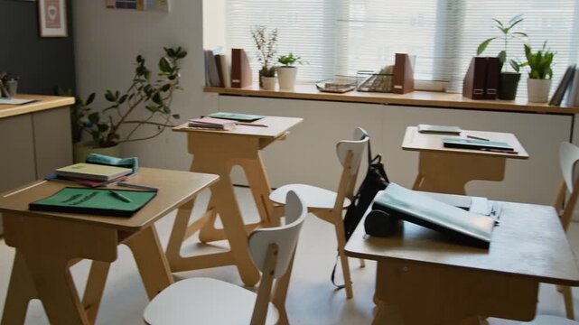 Full panning no people shot of middle school classroom with student desks, chairs, textbooks, diagram of human body on board, educational posters on walls, for health education lesson
