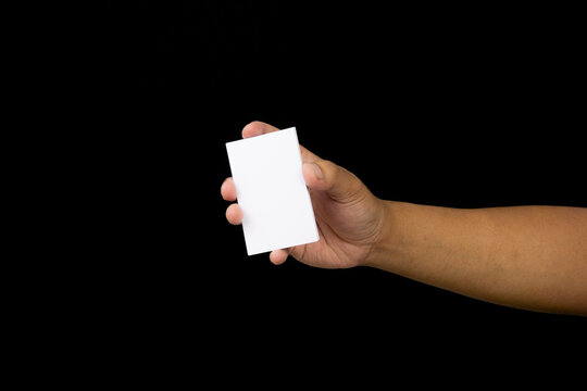 Hand holding a blank business card.  Isolated on black background.