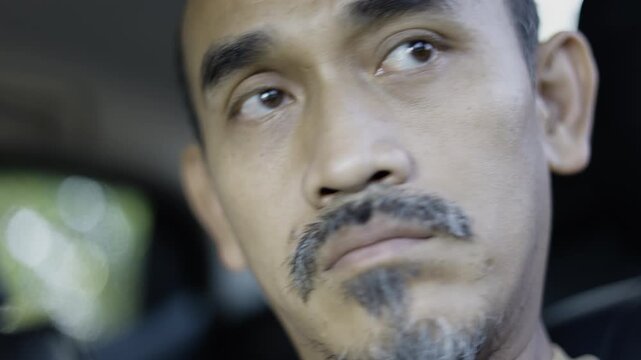 Close Up Southeast Asian Man Face Sitting In Car, A calm film of Southeast Asian man in car, relaxed expression with natural morning, perfect for everyday life or realistic lifestyle documentary.