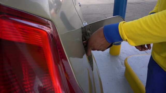 A man refuels a car with gasoline at a gas station, Pumping equipment gas at gas station Hand refilling the car with fuel, close-up, transportation