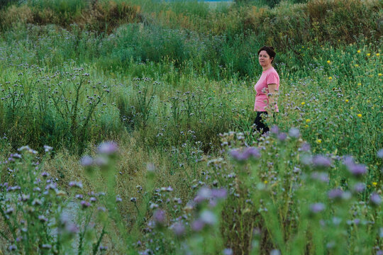 woman among plants in the field in spring